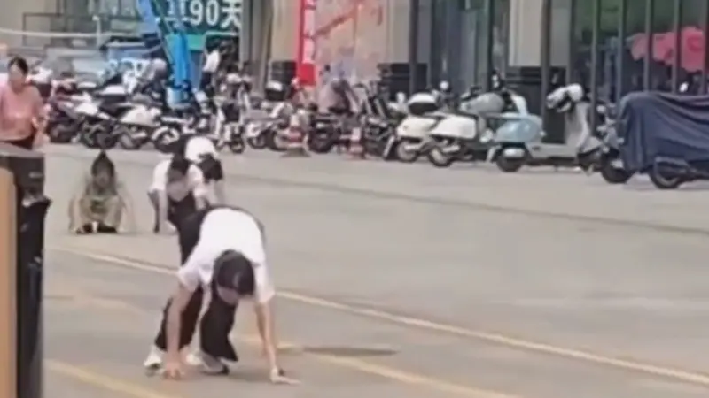 ▲中國廣東惠州市街頭，昨（16）日有多名男女集體四肢著地爬行，並發出像是狗叫的聲音，持續了10多分鐘，怪異景象吸引路人關注。（圖／翻攝自微博）