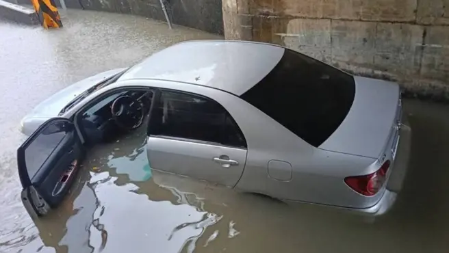 ▲ 宜蘭頭城外澳接天宮附近地下涵洞因豪雨積水，一輛銀色轎車誤闖陷入水中，車主受困近兩小時後脫困，愛車半淹泥水損失慘重。（圖／翻攝畫面）