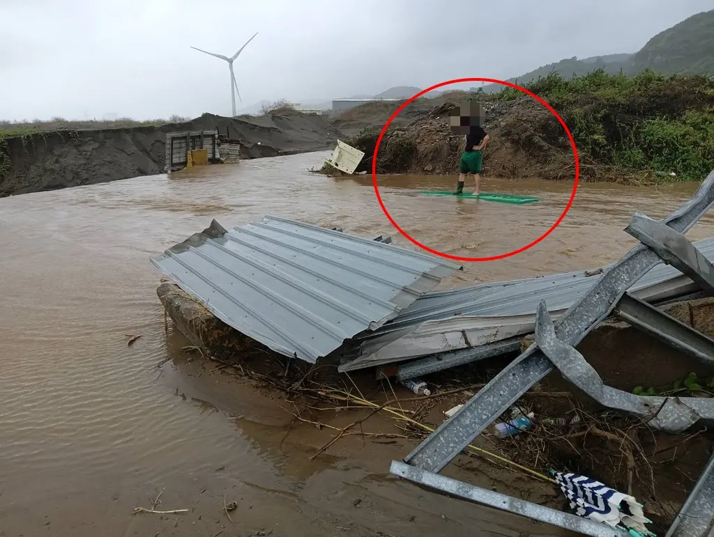 ▲北台灣雨勢不斷，今天下午一輛郵務車不小心開進暴漲溪水遭滅頂，郵差急爬車頂呼救。（圖／民眾提供）