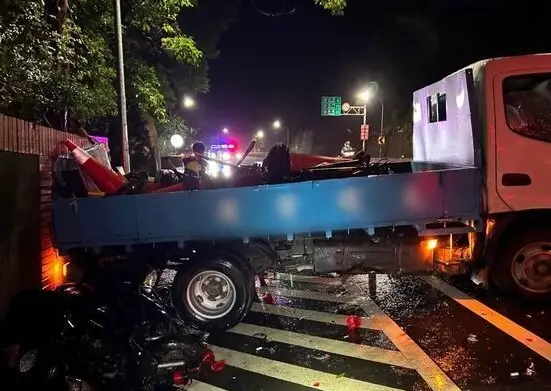 ▲ 新北淡水23日晚間雨天傳嚴重車禍，44歲貨車司機過彎失控打滑逆向撞機車，56歲婦人被夾車斗與圍牆間。（圖／翻攝畫面）