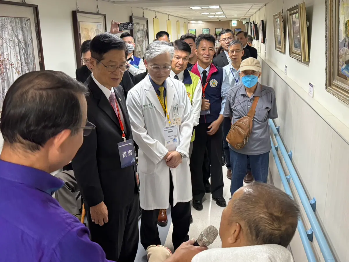 ▲口足畫家童福財（右下）向台中榮總院長傅雲慶等貴賓導覽畫作。（圖／台中榮總提供）
