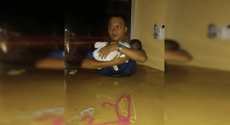 ▲馬來西亞霹靂州太平水災中，一名男子挺身抱起鄰居嬰兒涉水逃生，溫馨畫面感動全網。（圖／翻攝自每日新聞）