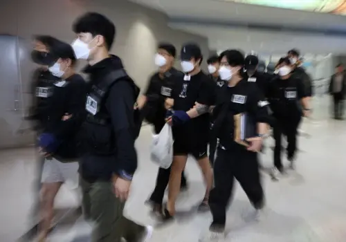 ▲在柬埔寨涉入犯罪活動的64名韓國公民，10月18日由警方押送，自金邊德崇國際機場搭乘包機返抵首爾仁川國際機場。（圖／路透社／達志影像）