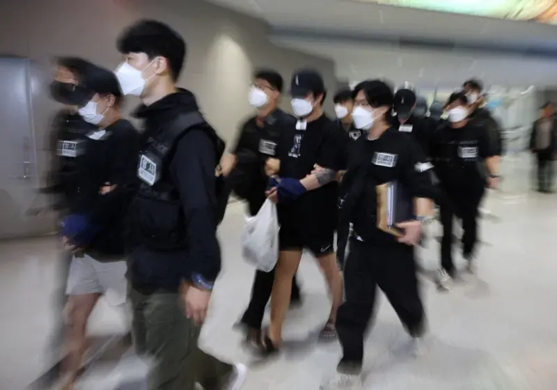    ▲在柬埔寨涉入犯罪活動的64名韓國公民，10月18日由警方押送，自金邊德崇國際機場搭乘包機返抵首爾仁川國際機場。（圖／路透社／達志影像）  