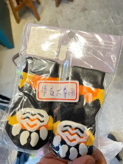 ▲其他志工得知小白黑黑是導盲犬後，才開始在櫃子裡翻找，證實故事館有為導盲犬預備的專用襪套。（圖／翻攝連惠蘭臉書）