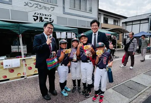 ▲ 平戶市長黑田成彥陪同黃偉哲發放台南果乾給民眾試吃。（圖／南市府提供）
