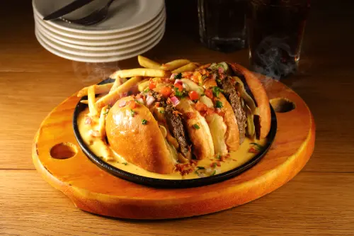 ▲滋滋作響的「起司熔岩堡」，燒熱的鐵盤上滾滾起司白醬好誘人。（圖／開展集團提供）