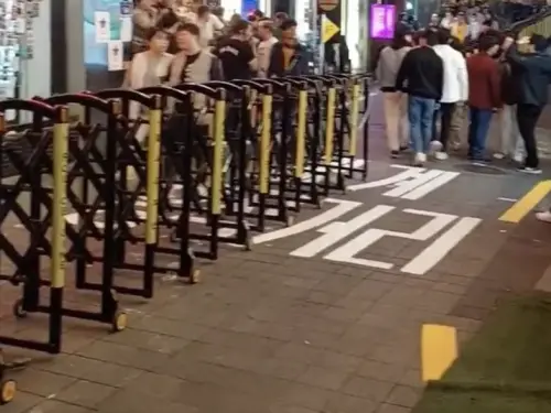 ▲梨泰院的道路中間直接擺放路障，作為雙向分流的界線，防止人潮來去全都擠在一起。（圖/推特@potxxxfan）