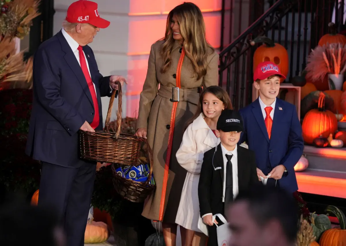 ▲川普結束亞洲行、抵達美國後，幾乎未做任何休息，直接參加白宮的萬聖節活動，和妻子站在門口發糖。圖為扮成川普夫妻和特勤局特工的3姊弟。（圖／美聯社／達志影像）