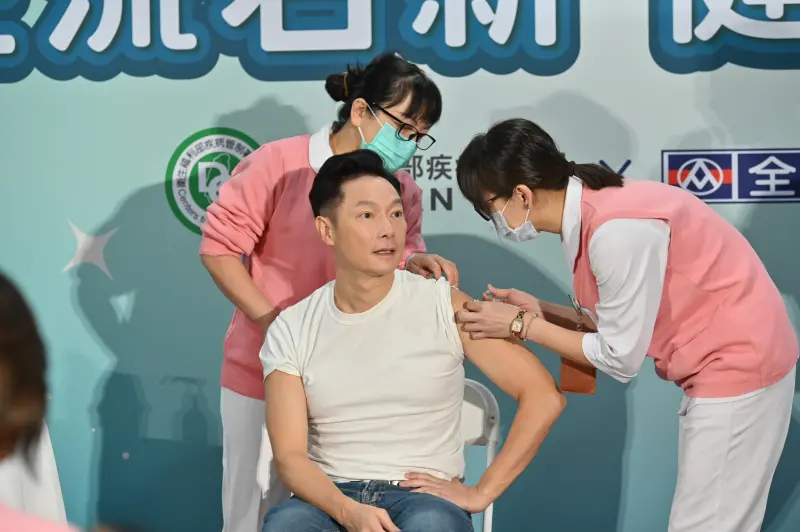 ▲謝祖武擔任防疫大使，挽袖示範接種疫苗（圖／疾管署提供）