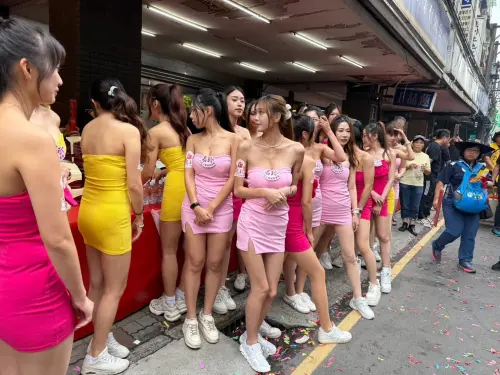 ▲粉紅超跑行經板橋區長江路一段時，30多位美女禮生整齊列隊迎接媽祖。（圖／民眾提供）