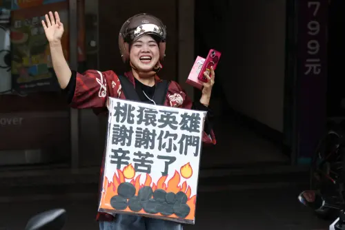 ▲球迷舉著看牌，一路跟著樂天桃猿封王遊行車陣前進。（圖／記者朱永強攝，2025.11.2）