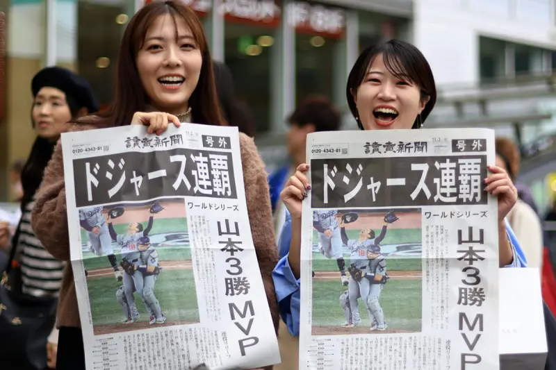 ▲洛杉磯道奇世界大賽第7戰中以5：4延長逆轉擊敗多倫多藍鳥，日本民眾湧上街頭慶祝，「我們為身為日本人感到驕傲！」的呼喊此起彼落，東京更在緊急發行了道奇奪冠特刊報紙，各大新聞攤前排滿搶購人潮。（圖／美聯社／達志影像）
