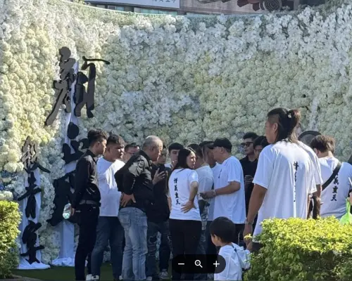 ▲顏正國告別式的會場有白色花海牆設置，上面打出「顏正國殺青宴」的字樣，感覺高雅莊嚴，會場還有百位黑衣人來送他最後一程。（圖／記者蘇詠智攝）