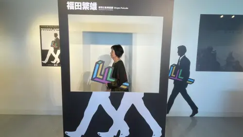 ▲福田夫人跟其先生福田繁雄的作品一起進行自拍。（圖／翻攝畫面）