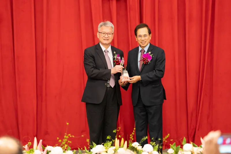 台中中山醫大65週年校慶會上，校長黃建寧頒授吳元煌名譽博士學位，由同窗邱文達(右)代為領取，（圖／中山醫大提供）