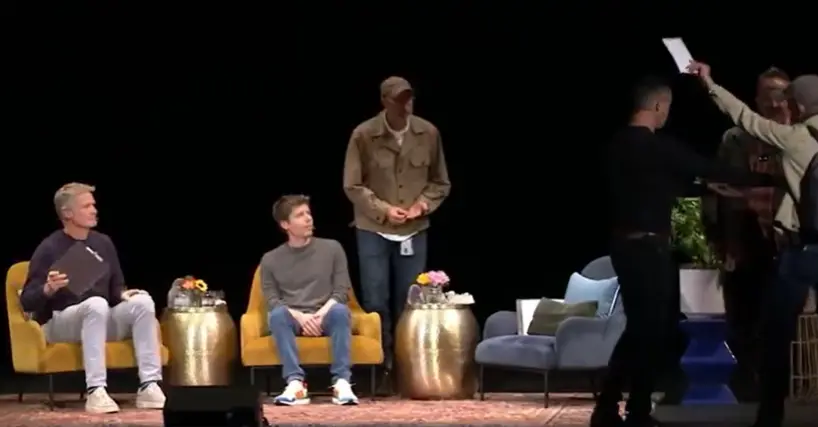 ▲OpenAI執行長奧特曼近日在一場座談活動上，突遭一名男子衝上台給傳票，畫面相當尷尬。（圖／翻攝自Ｘ）