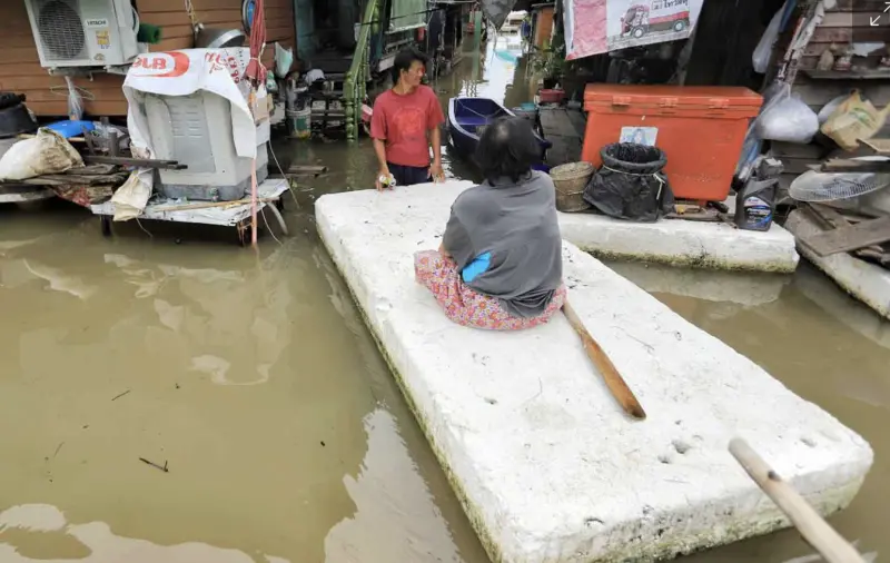    ▲泰國民眾以泡棉板代步穿越積水街道，家戶仍被洪水圍困，部分地區排水困難。（圖／翻攝自曼谷郵報）  