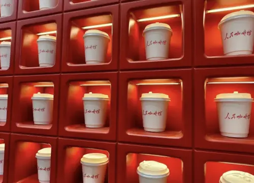 ▲紅底展示牆上整齊擺放印有「人民咖啡館」字樣的紙杯，強烈的紅白對比成為社群熱門拍照背景。（圖／翻攝自小紅書）