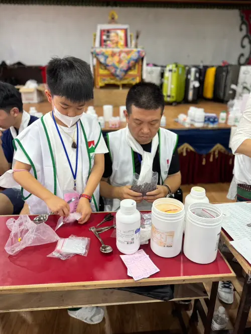 ▲孩子們擔任尼泊爾醫療志工，協助包藥。（圖／吳正義提供）