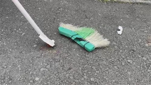 ▲高雄市仁武區一名狗主人帶著未繫繩的比特犬散步時，犬隻突然攻擊路邊一隻黑狗，為了阻止犬隻互咬就連掃把也被打斷。（圖／民眾提供）