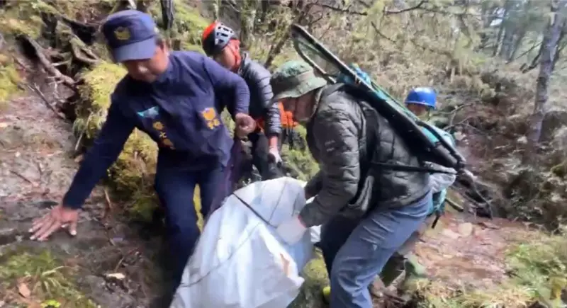 ▲保七刑大隊長登山猝逝，南投縣消防局搜救人員將遺體合力搬運到空曠處，由空勤直升機吊掛運下山。（圖／民眾提供）