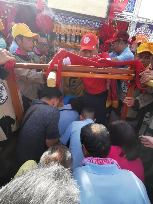 ▲楊登嵙老師提醒，躦轎底時，不能起身或觸碰鑾轎，背包放在胸前，好讓鑾轎通過，不能戴帽子，要記得脫帽。（圖／楊登嵙提供）