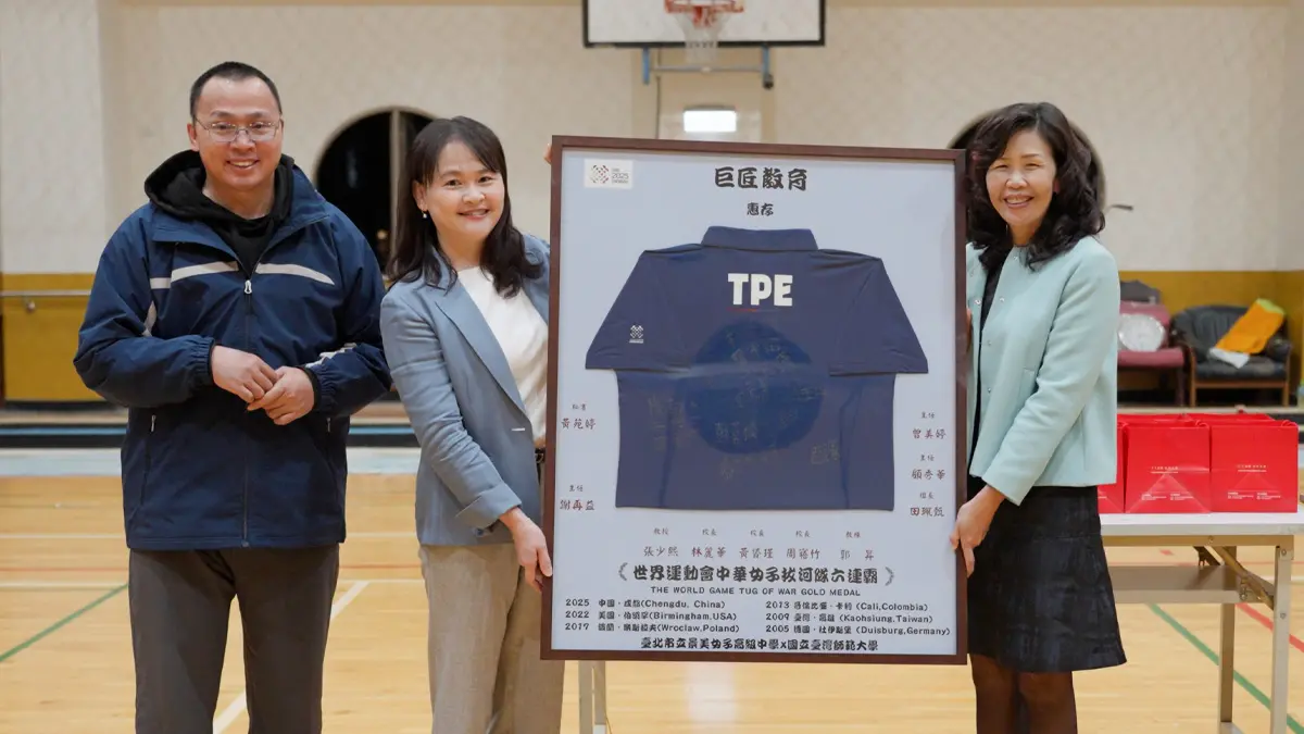 ▲景美女中校長周寤竹及拔河隊總教練郭昇，致贈世運會六連霸紀念衫予巨匠教育總經理王萱慧。（圖／巨匠外語提供）