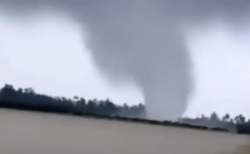 ▲龍捲風發生於24日下午約4點20分，當地居民拍下當時的景象並上傳至社群平台，顯示強風吹襲期間村莊附近天空急速旋轉，隨後席捲地面建物。（圖／翻攝自影片） 
