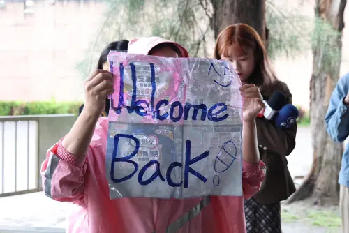 ▲12月1日上午下雨，一名自稱朱學恒粉絲的林姓女子在台北監獄外面拿著「Welcome Back」的標語守候。（圖／記者朱永強攝）