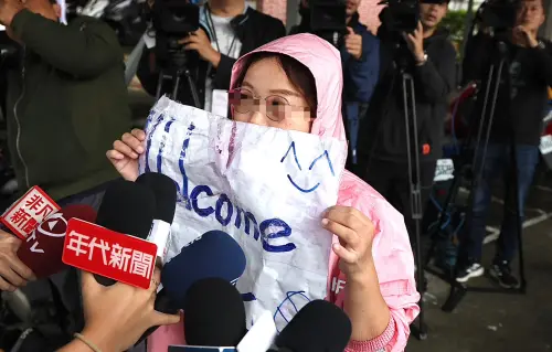 ▲12月1日上午下雨，一名自稱朱學恒粉絲的林姓女子在台北監獄外面拿著「Welcome Back」的標語守候。（圖／記者朱永強攝）