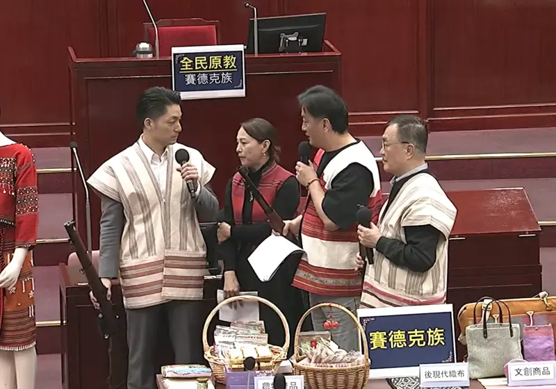 ▲原住民議員李傅中武拿出三把道具獵槍，擺放好5隻山豬娃娃，並邀請蔣萬安以及副市長李四川體驗原住民狩獵文化。（圖／擷取自《台北市議會》YouTube）