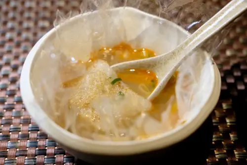 ▲「鼎邊銼玻璃燒」重現基隆經典廟口小吃，還特意以耐熱玻璃紙盛裝，並擺放在外型乍看誤以為是拋棄式的碗內。（圖／記者葉盛耀攝）