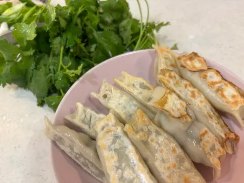 ▲記者把水餃皮拉成橢圓形，也把香菜內餡一半包成鍋貼形狀，煎來吃超美味。（圖／記者徐銘穗攝）