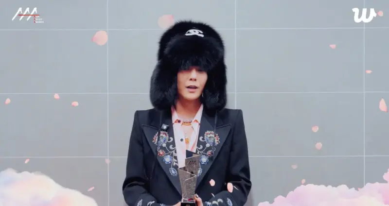 ▲GD突然以影片方式現身AAA頒獎典禮，獲頒10週年傳奇男歌手獎，頭戴超大頂香奈兒皮草帽亮相。（圖／翻攝自Ｗeverse）