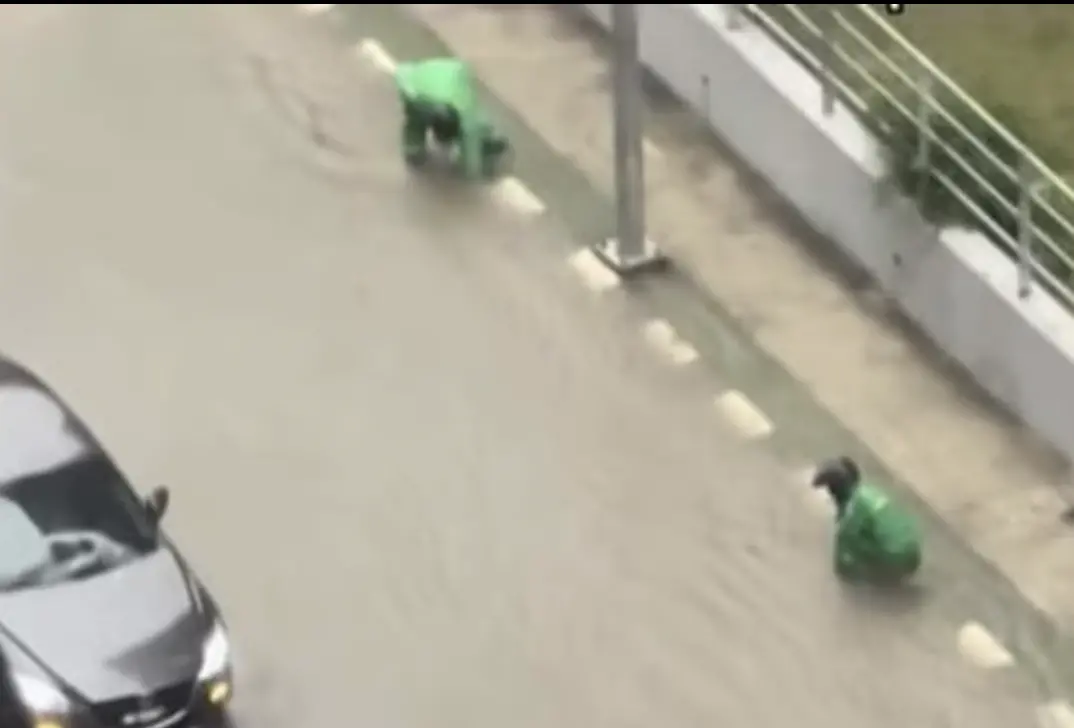 ▲2名外送員冒雨下車清理水溝，讓積水迅速退去，被路人拍下後在社群掀起熱烈迴響。（圖／翻攝自TikTok）