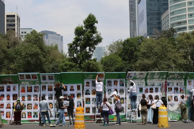 ▲當地民眾在墨西哥城改革大道環島中央隔離帶上,張貼失蹤者的肖像。(圖/美聯社/達志影像)