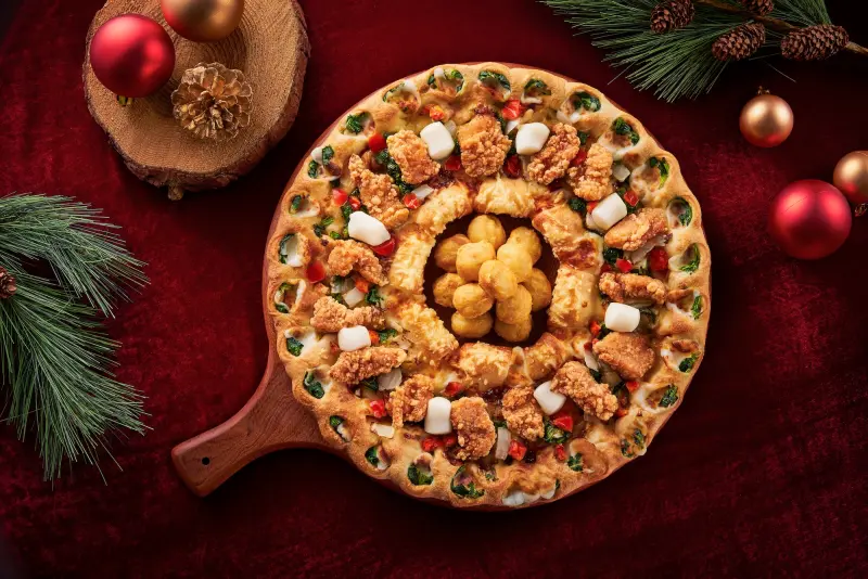 ▲必勝客睽違4年回歸改版「聖誕花圈黃金雞披薩」開賣，肉量升級、在中心放滿酥炸嫩雞球，搭配「黑鑽松露火山熔岩餅皮」開吃聖誕超級大餐。「買一送一」免優惠代碼買法推薦。（圖／必勝客pizzahut.com.tw）