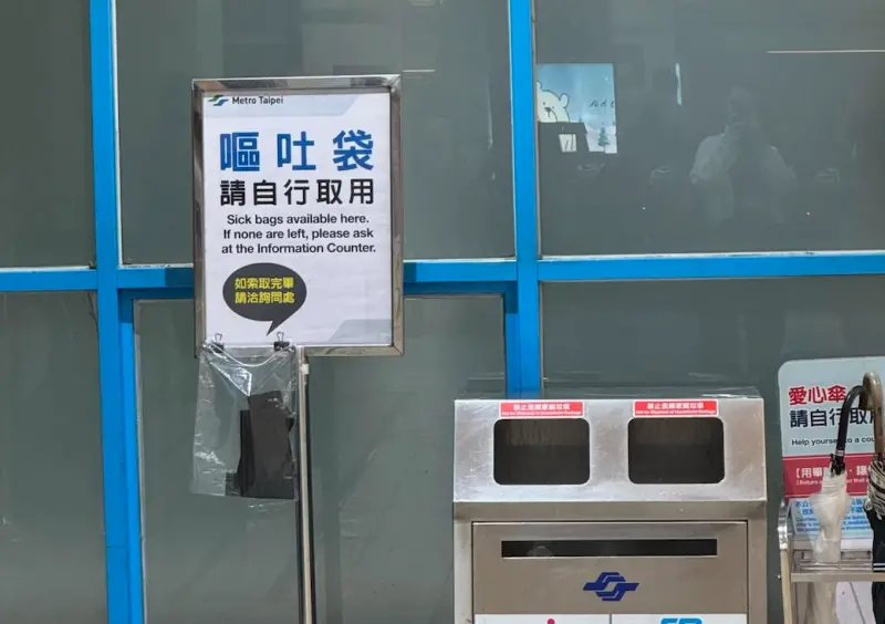 ▲台北捷運近期在多個車站同步擺出告示牌，提醒民眾「嘔吐袋可免費自取」，似乎已為年底尾牙飲酒潮提前備戰，許多民眾也在其他站點如台北車站、大安、南京復興、大坪林等處看見同款服務。（圖／翻攝自Threads@melody8805）