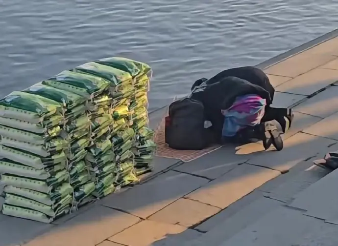 ▲中國遼寧日前有民眾在江邊「放生白米」，先跪拜行禮後將一袋袋白米往江中倒，讓其他民眾看傻眼。（圖／翻攝自微博）