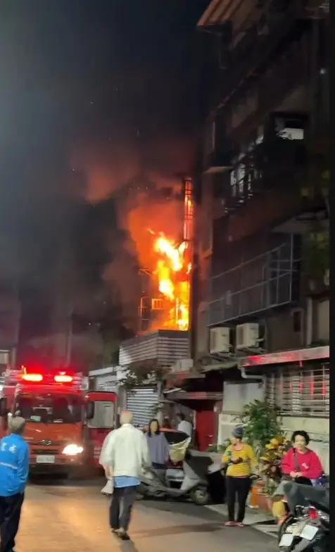 ▲新北市新莊1處公寓今天清晨驚傳火警，火光從二樓公寓窗口不斷竄出，消防人員射水灌救。（圖／民眾提供）