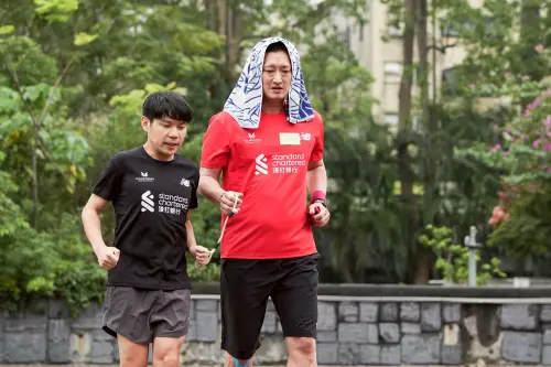 ▲視障跑者與陪跑員進行陪跑繩使用練習，讓陪跑員成為視障跑者最可靠的夥伴。（圖／渣打台北公益馬拉松團隊提供）