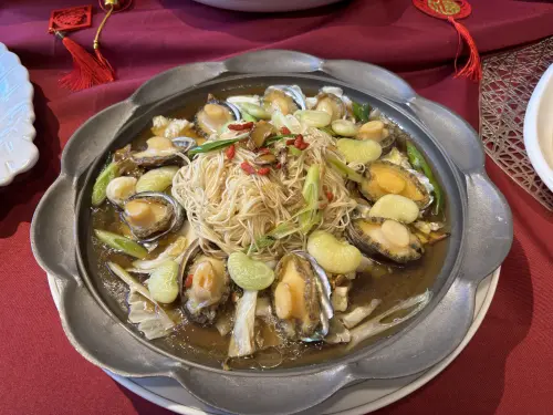 ▲「馬運亨通麻香鮑」採用老薑與北港麻油煸香後，加入米酒與鮑魚燜煮入味，平鋪麵線上淋上高湯蒸煮，澎湃美味。（圖／記者金武鳳攝，2025.12.17)