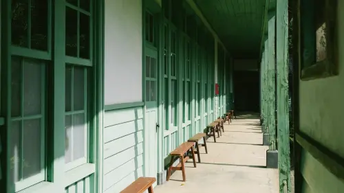 ▲北投中心新村木造走廊延伸，午後光影灑落窗框與長椅，空間靜謐而緩慢。（圖／翻攝畫面）