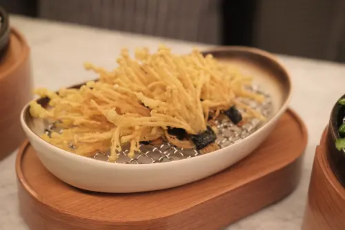 ▲「金針酥扇」是把新鮮金針菇排列成扇形後，酥炸至金黃酥脆。（圖／記者葉盛耀攝）