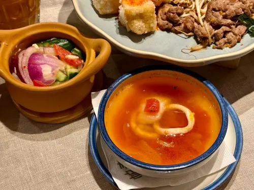 ▲例湯裡給不少魷魚和魚片；開胃小點涼拌雞肉、小黃瓜、洋蔥塞滿滿，份量很有誠意。（圖／記者蕭涵云攝）