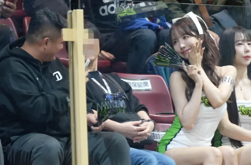 ▲三上悠亞（右2）今晚首度應援，下半場開始時，直接坐在球迷旁邊，讓該位球迷害羞到臉紅，根本不敢直視女神，後來才鼓起勇氣拿起手機。（圖／記者張一笙攝）