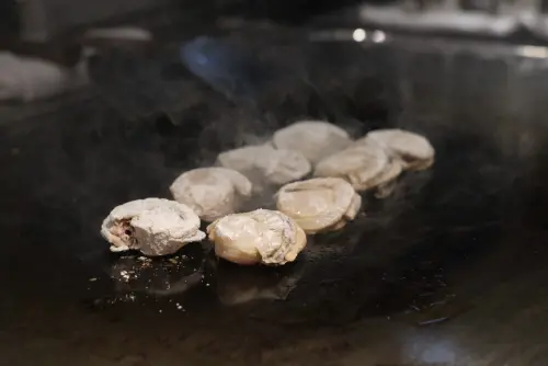 ▲島語桃園台茂店的鐵板區新推出「魚子醬蒜香帆立貝」。（圖／記者葉盛耀攝）