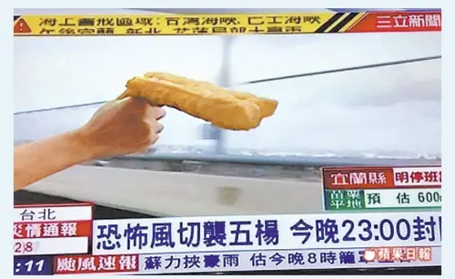 A San Li reporter measures windspeed with a snack. (Screenshot: CTBC University of Science and Technology, PTT, San Li)