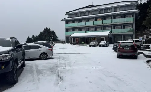 ▲松雪樓前地面蓋上一層薄薄的雪。（圖／林業及自然保育署南投分署提供，2026.01.02）